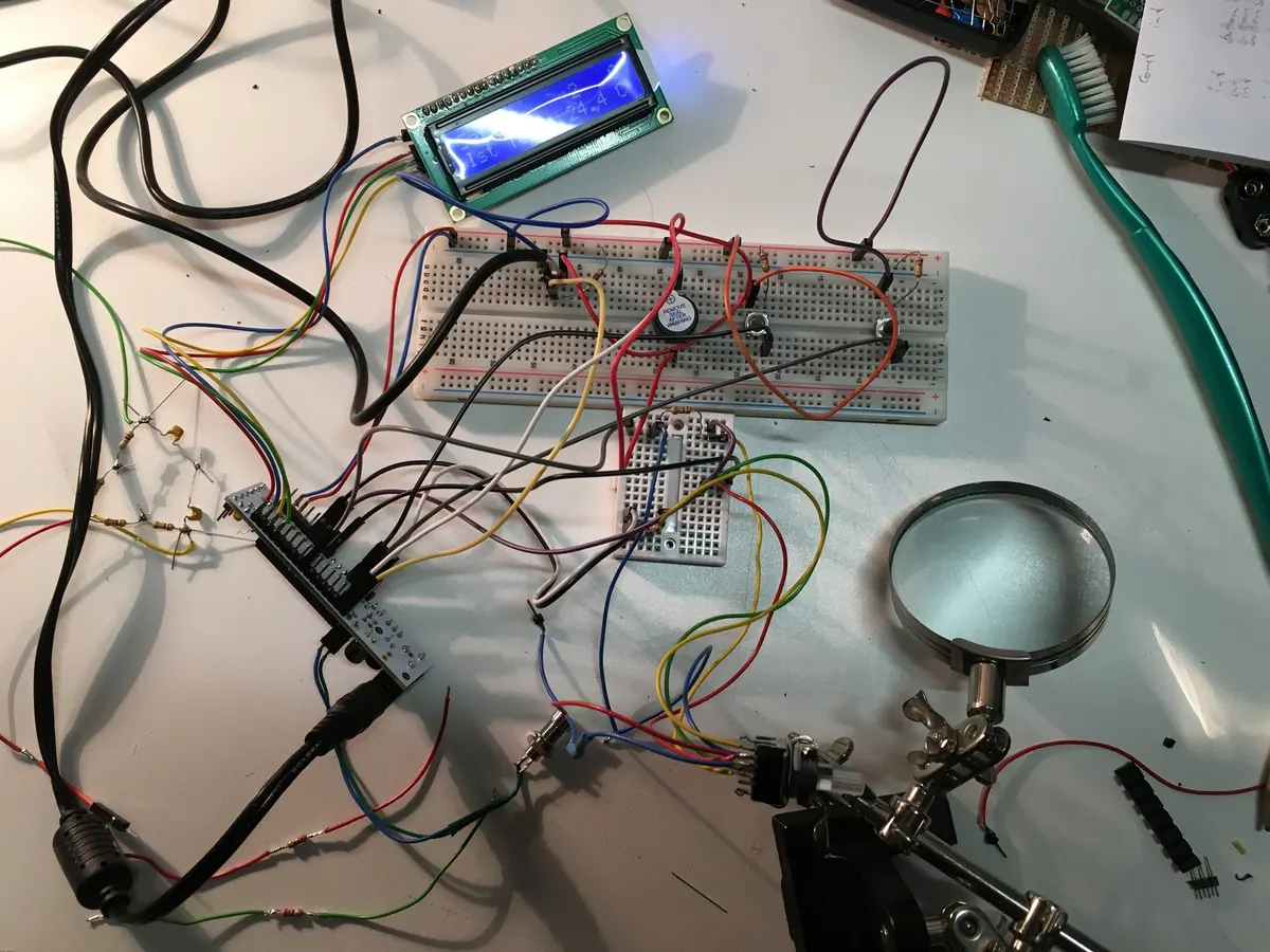 Arduino mit LCD-Display auf einem Steckbrett, umgeben von Kabeln und Werkzeug