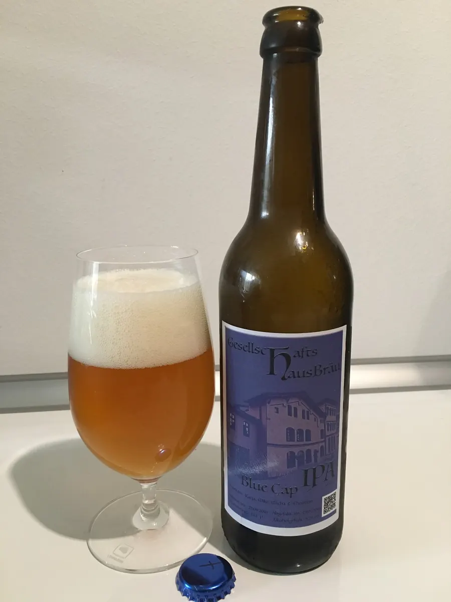 Bierflasche mit Etikett neben einem eingeschenkten Glas